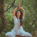 Woman meditating in a peaceful forest setting, embracing calmness and balance.